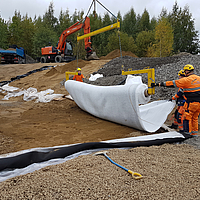 Employees laying Tektoseal Active oil absorption mat with a laying traverse
