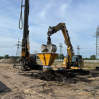 Excavator fills a column encased in Ringtrac® with the help of a hopper