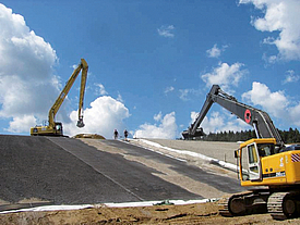 With the help of two wheel loaders and the installation of geosynthetics, a landfill body is constructed