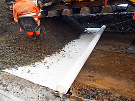 Installation of geosynthetics in the substructure of the track bed to reinforce the base course stabilization.