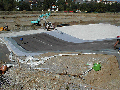 Geosynthetic clay liners are laid using an excavator