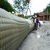 Workers fill the Incomat® Pipeline Cover with concrete pump via the filler neck