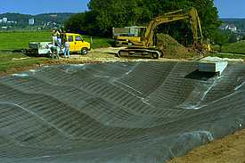 Close-up of the installation of concrete mats for waterproofing and erosion control of the stormwater retention basin.
