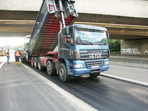Lorry delivering new asphalt to the road.