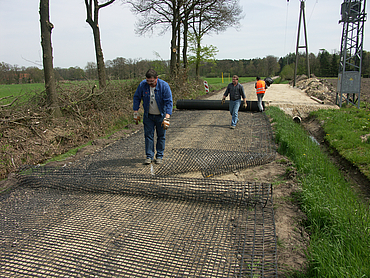 Basetrac Grid is being laid by several workers along a path