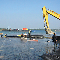 Professional installation of a filter layer on a waterbody bed to prevent contaminant release