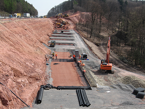 A building site with various pieces of construction machinery and several workers