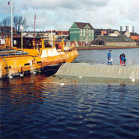 Workers install geotextile materials for harbor bottom protection