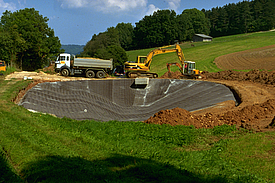 Installation of concrete mats for waterproofing and erosion control of the stormwater retention basin.